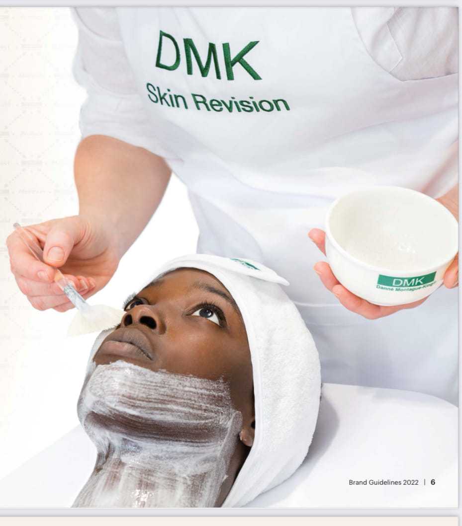 Facial treatment being applied at a spa by an esthetician wearing a DMK apron.