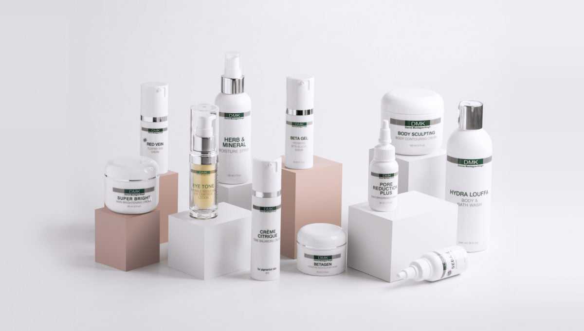 Skincare products arranged on geometric blocks, featuring various creams and lotions.
