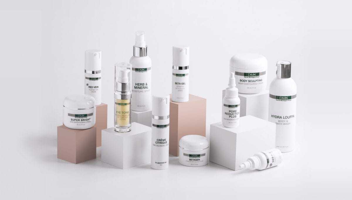 Skincare products arranged on geometric blocks, featuring various creams and lotions.